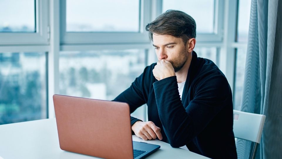 How to Test Hormone Levels hero image of a man looking up the answer on his computer.