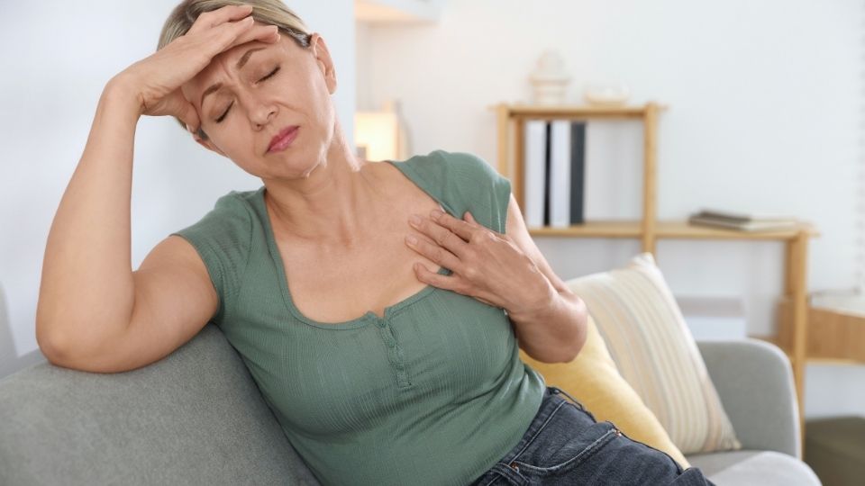 What Are the Signs That You Need Hormone Replacement Therapy hero image of a woman experiencing a hot flash.