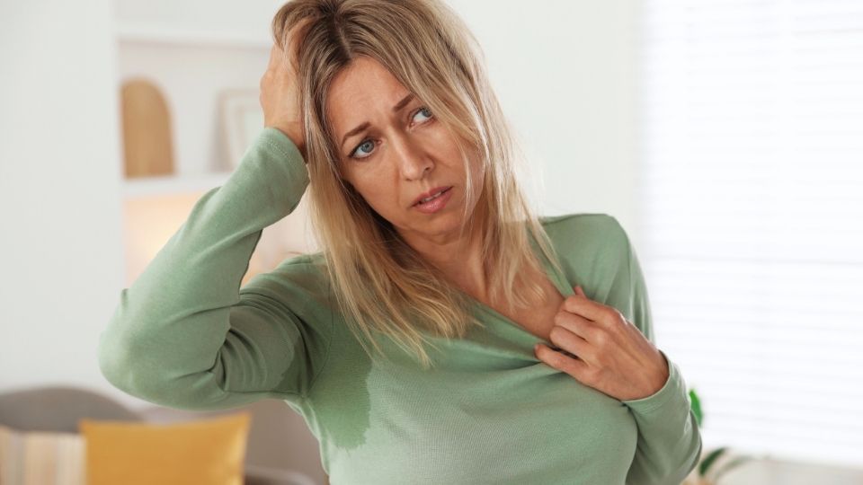 vaginal estrogen cream hero image of a woman experiencing hot flashes in menopause.